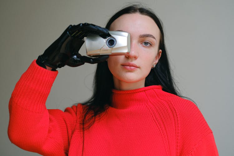 Woman With Prosthetic Hand Holding A Film Camera