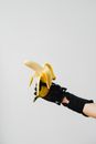 Person in Black Shorts and Yellow Sneakers Holding Banana Fruit