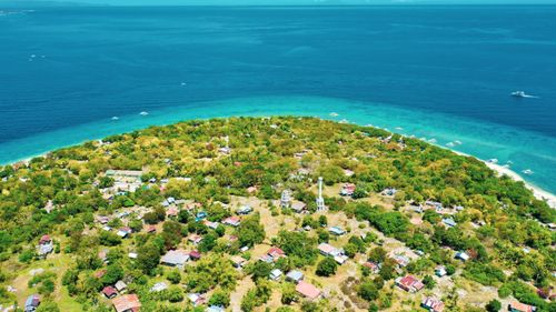 Free Aerial view of calm blue sea water near shore with green exotic plants and small buildings Stock Photo