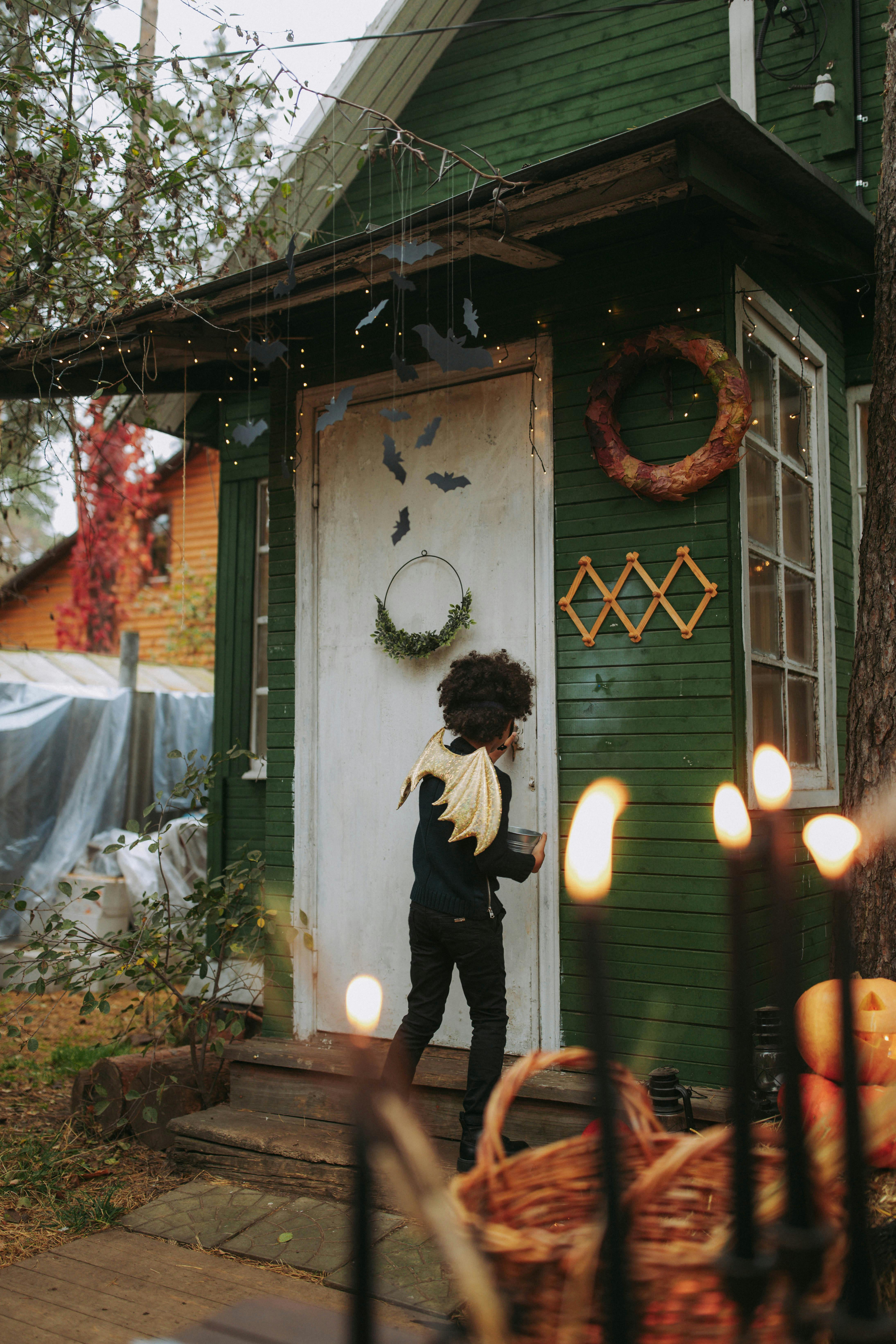 万圣节那天，一个穿着戏服的孩子走近装饰好的温室，准备玩“不给糖就捣蛋”的游戏