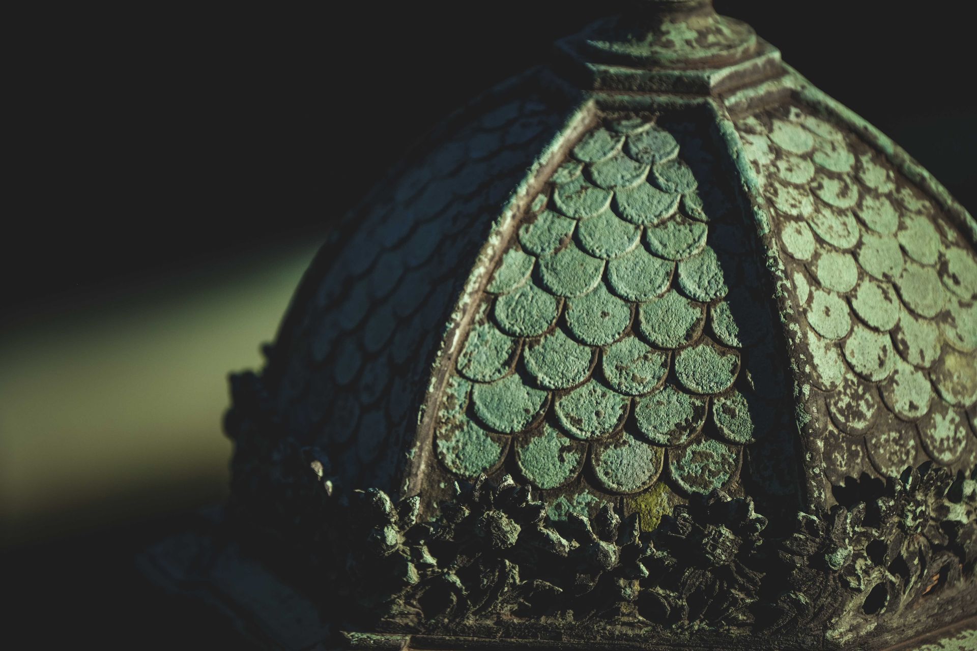 Closeup detail of ancient metal street lantern with weathered ornamental details on sunny day