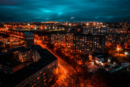 Free Dramatic nighttime view of a cityscape with vibrant lighting and buildings under a dark sky. Stock Photo
