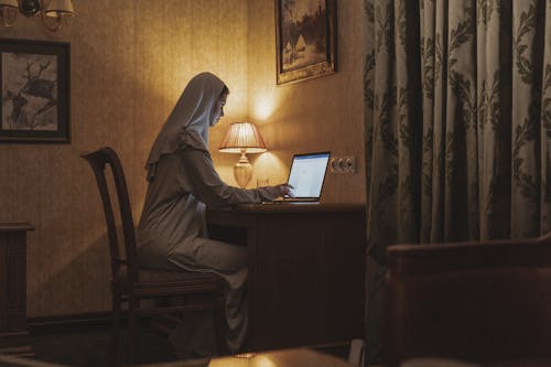 Free A Woman in Hijab Using a Laptop Stock Photo