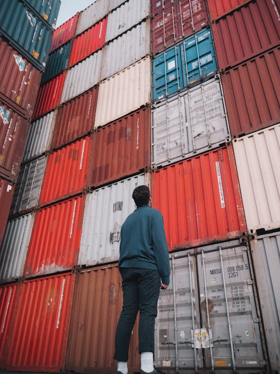 Free Man in Blue Dress Shirt Looking At A Stack Of Cargo Containers Stock Photo