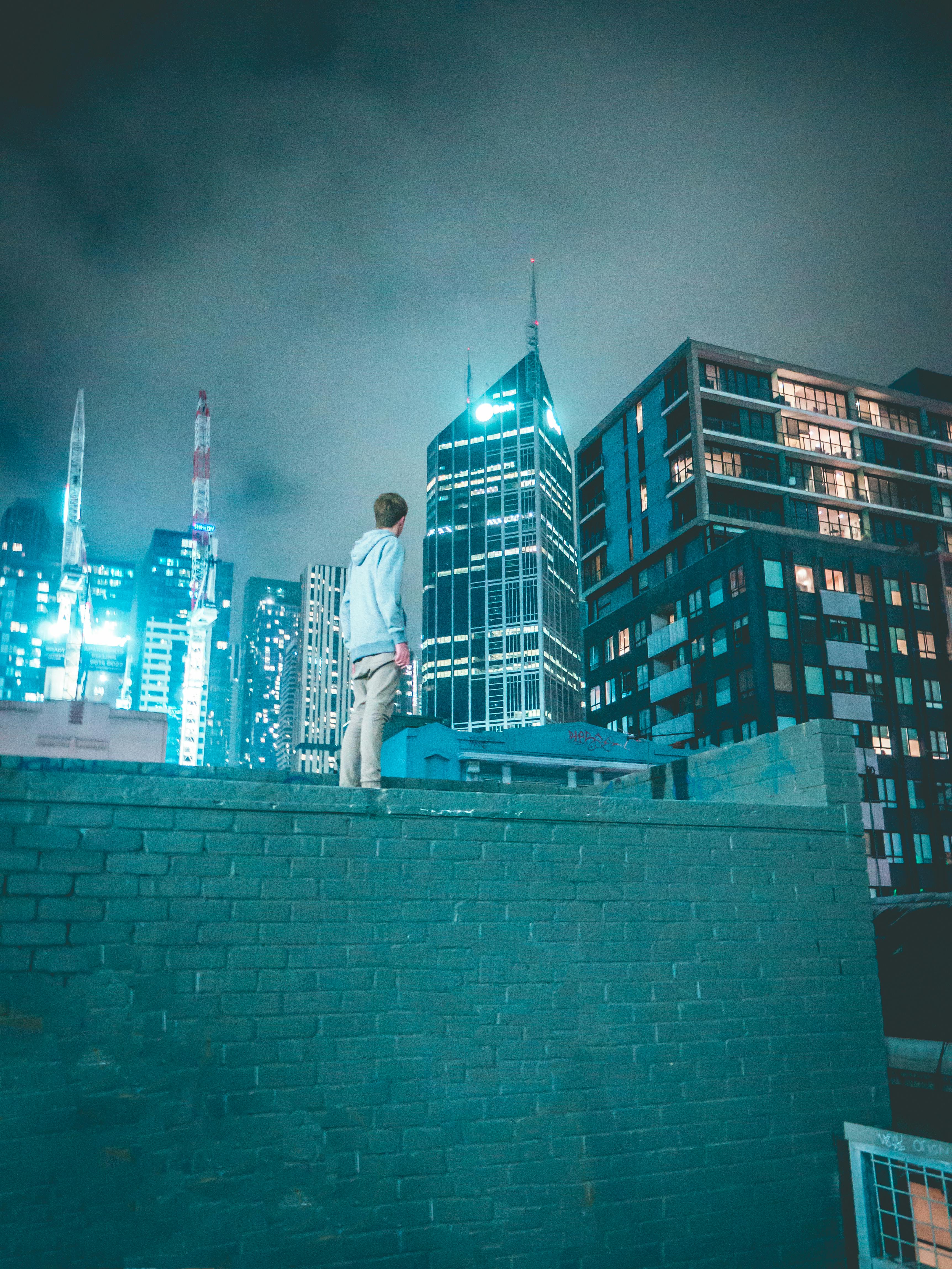 Man sitting beside glass window near high rise building photo