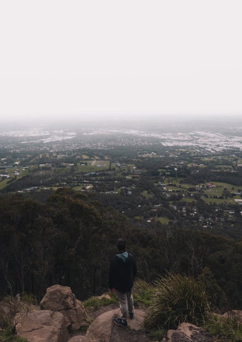 Free A Man Standing on a Rocky Cliff Stock Photo