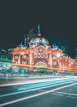 墨尔本标志性的弗林德斯街车站亮起了夜景，展现了这座城市充满活力的氛围