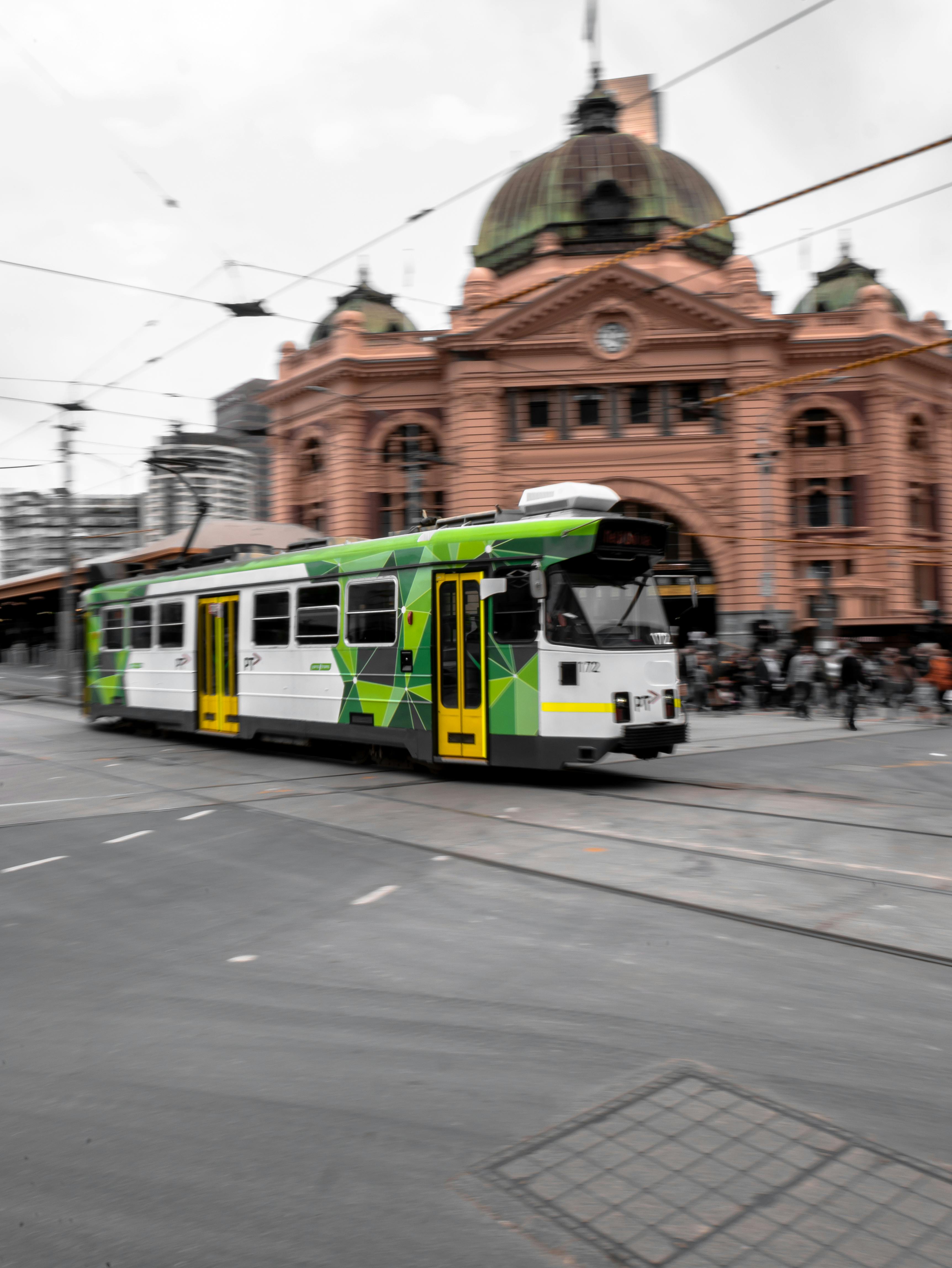 green and white tram on road