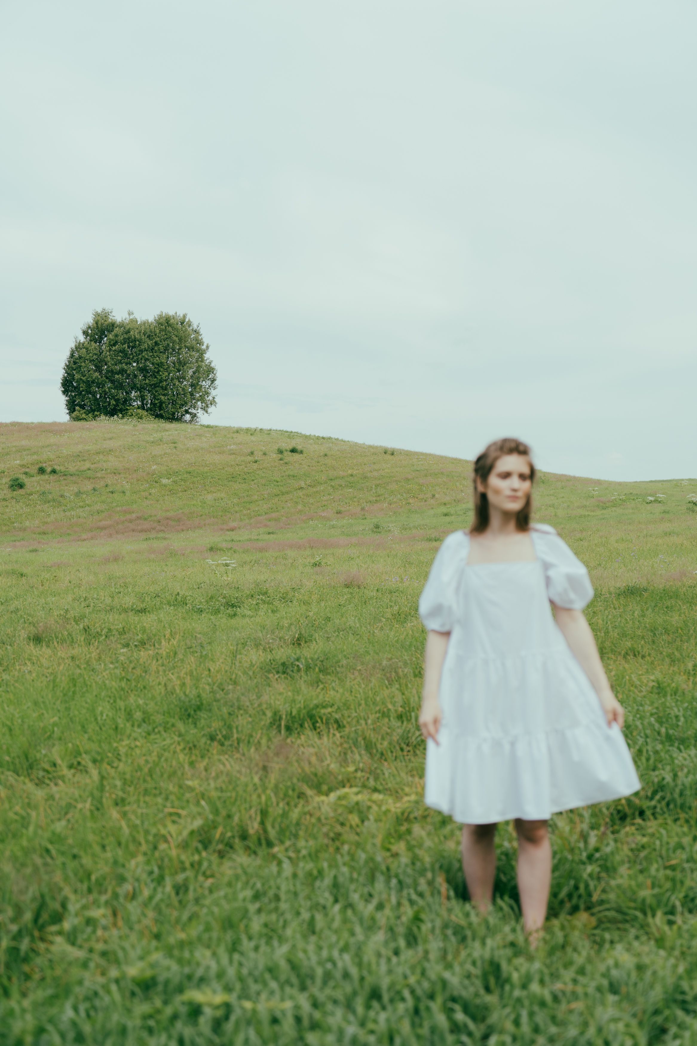 A Woman in White Dress Standing on Green Grass Field · Free Stock Photo