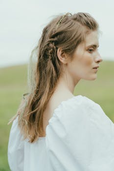 户外环境中，一位梳着辫子、穿着白色衬衫的女性侧面图