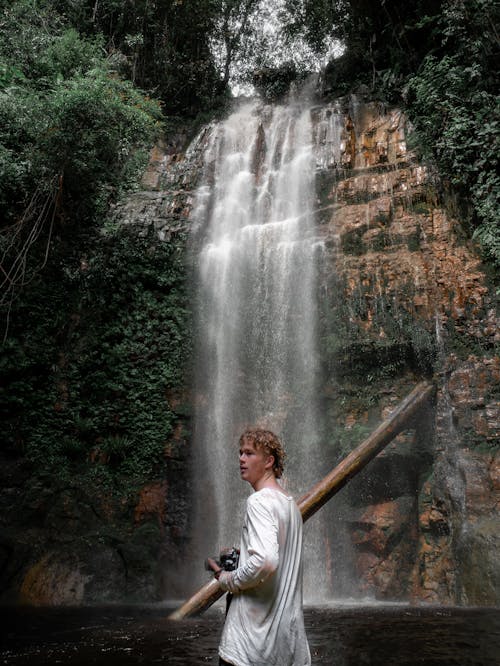 Man in White Shirt Standing Near Waterfalls