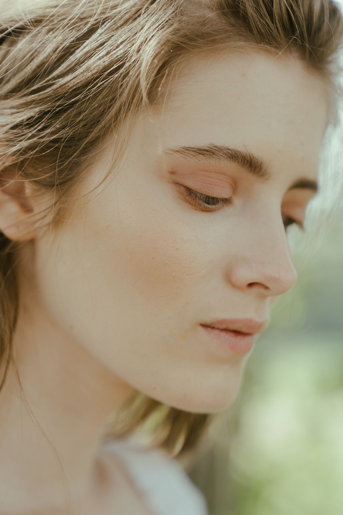 Side view of a woman with luminous skin in soft light