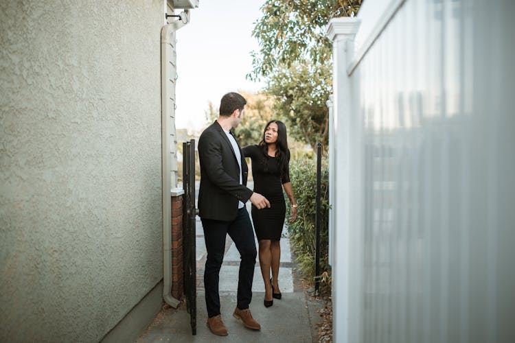 Man In Black Suit Standing Beside Woman In Black Dress