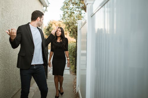 Man in Black Suit Standing Beside Woman in Black Dress