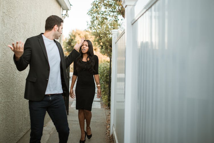 Man In Black Suit Standing Beside Woman In Black Dress