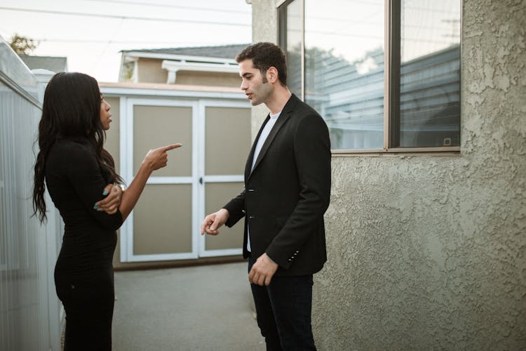 Man In Black Suit Standing Beside Woman In Black Dress