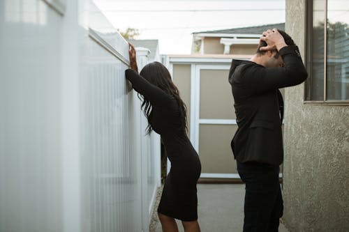 Uomo E Donna Che Baciano Vicino Al Muro Bianco