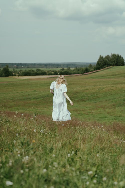 Blonde Woman in White Dress Walking on Hayfield