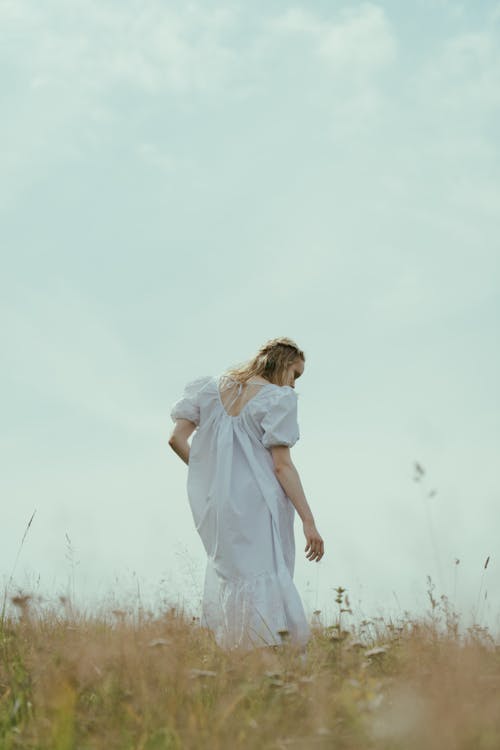 Blonde Woman in White Dress on Grassland