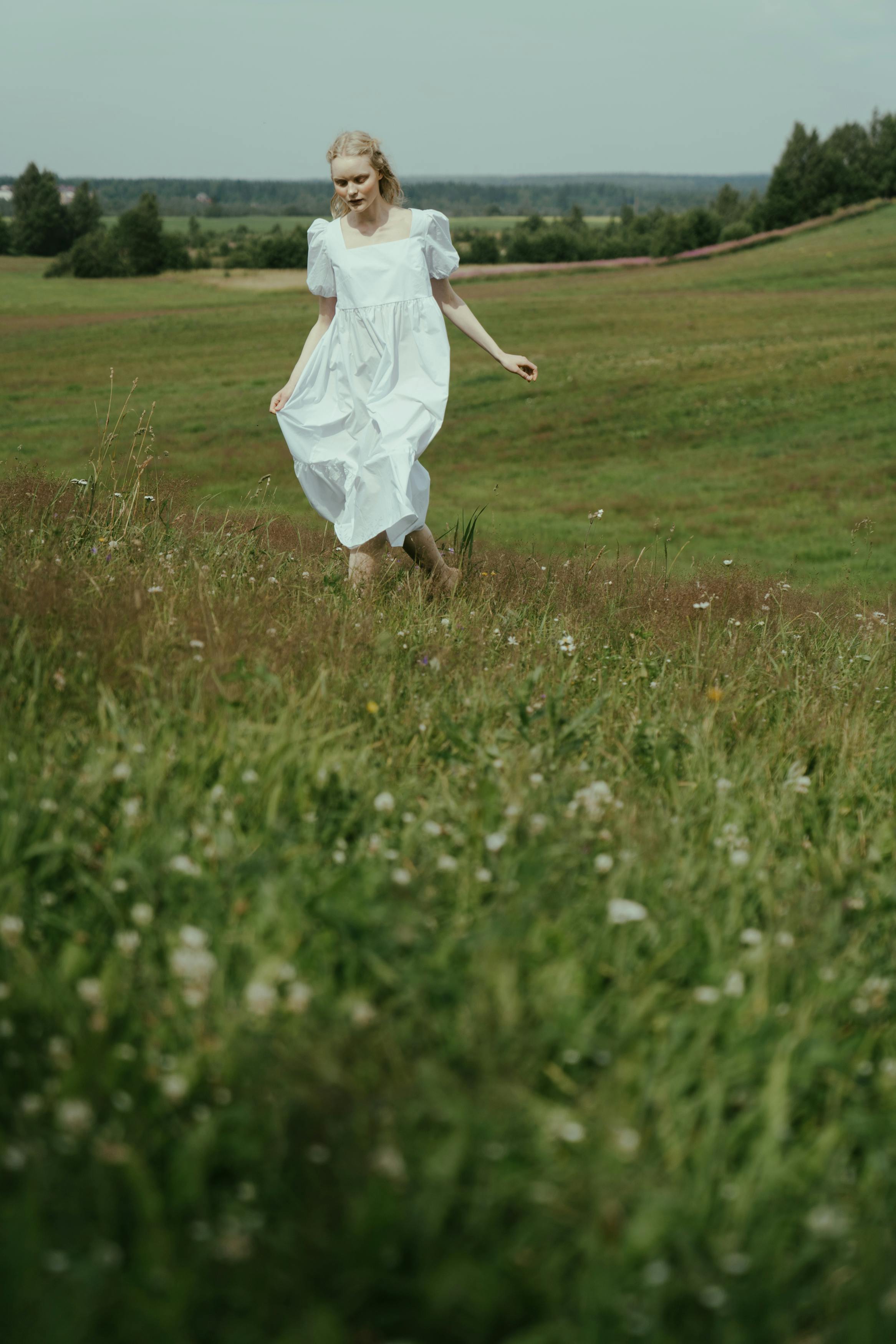 A Woman Walking Barefoot on the Grass · Free Stock Photo