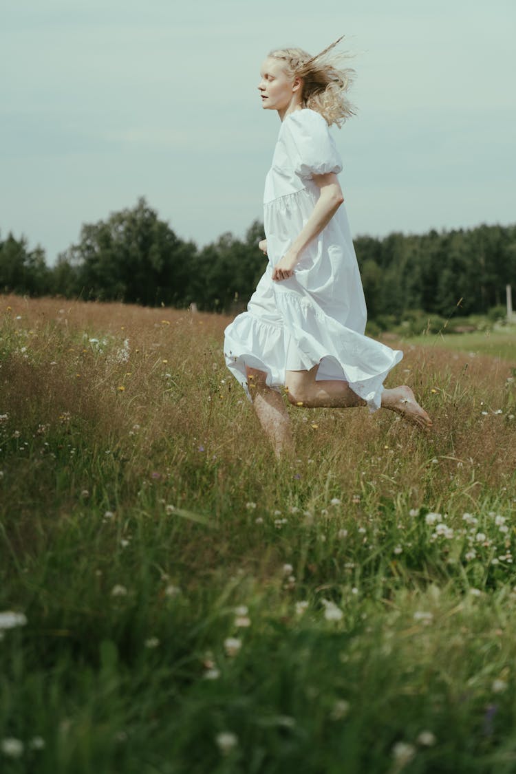 A Woman Running Barefoot On A Field