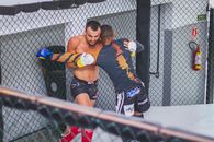 Man in Blue Jersey Shirt and Black Shorts Leaning on Gray Metal Fence
