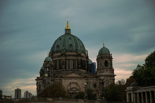 柏林大教堂的圆顶建筑映衬着喜怒无常的天空，构成了一幅戏剧性的景观