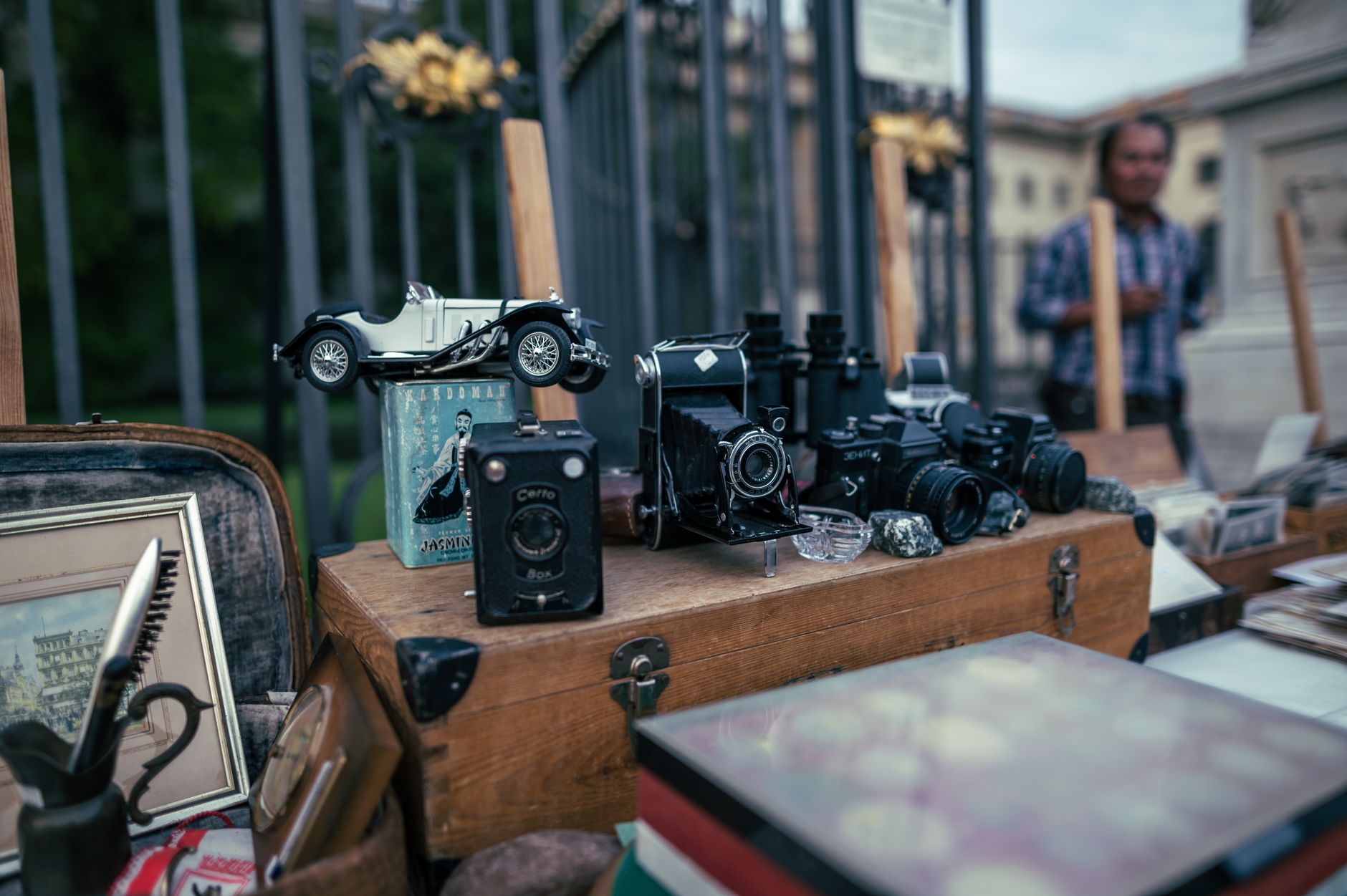 An assortment of vintage cameras and collectibles displayed at an outdoor flea market.