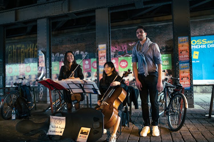 A Band Playing Classical Instruments Performing On A Street 