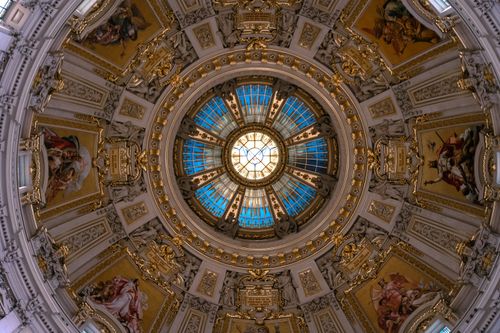 Free Stunning low-angle view of a richly decorated dome featuring a blue stained glass skylight. Stock Photo