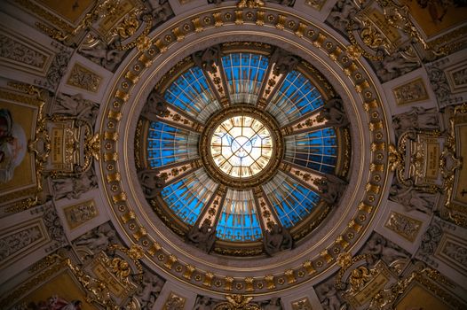 Stunning view of a detailed dome ceiling with intricate designs and bright blue sky.