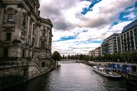 White and Blue Boat on River Near Building