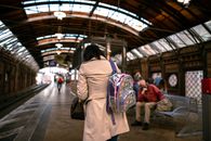 Woman in Brown Coat Standing on Train Station