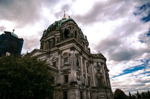 Free A dramatic low angle shot of the Berlin Cathedral against a cloudy sky, showcasing its architectural grandeur. Stock Photo