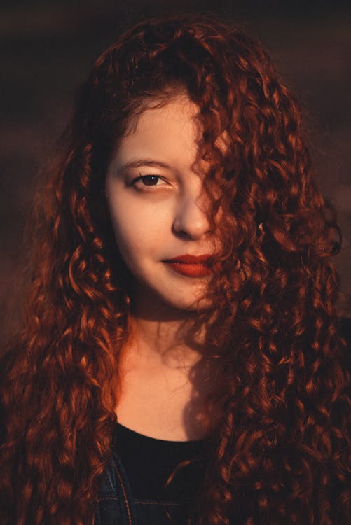 Dreamy woman with curly reddish hair