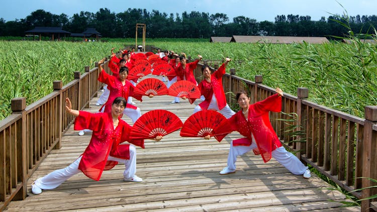 Women With Fans Performing On Footbridge