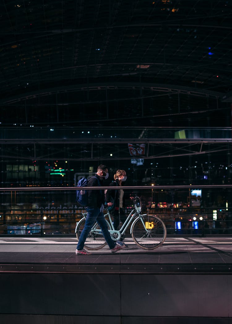 A Couple In Face Masks Walking In City 