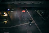 Man in Black Jacket and Black Pants Walking on Basketball Court