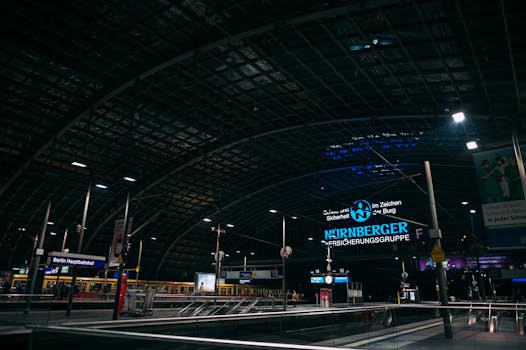 Illuminated Berlin Hauptbahnhof station at night showcasing modern architecture and transport hub.