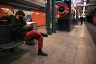 Man in Black Jacket and Red Pants Sitting on Black Chair