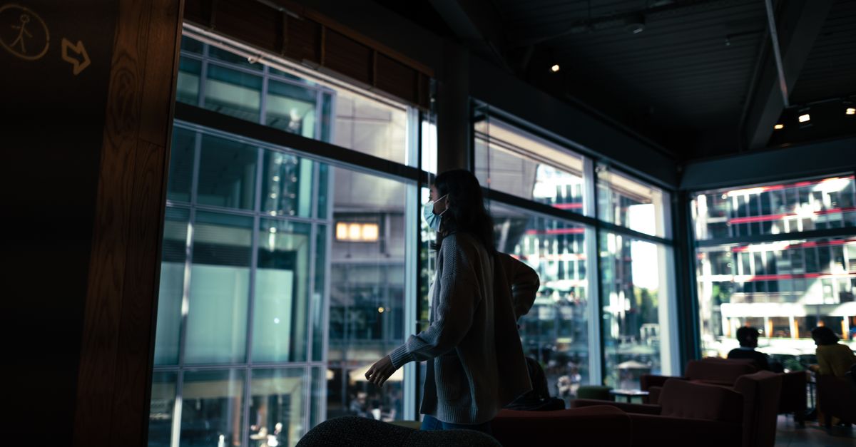A bright, modern church building with sunlight streaming through large windows, people arriving with coffee cups and smiles