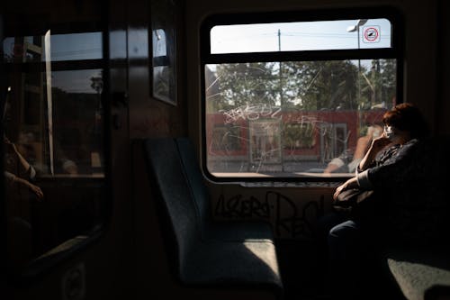 Woman Sitting in Train Compartment