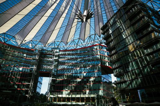 Futuristic architecture with a striking glass canopy and urban skyscrapers.