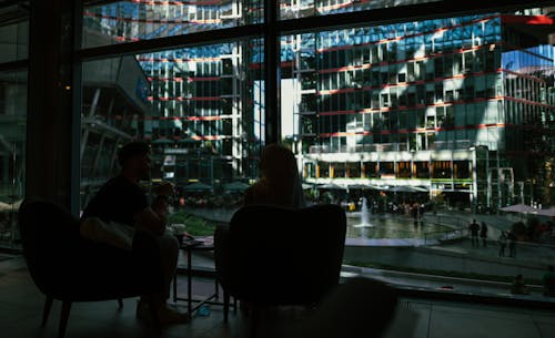 People Sitting on Chair Facing A Glass Window