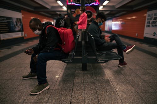 Free People Sitting on Black Chairs In A Subway Station Stock Photo