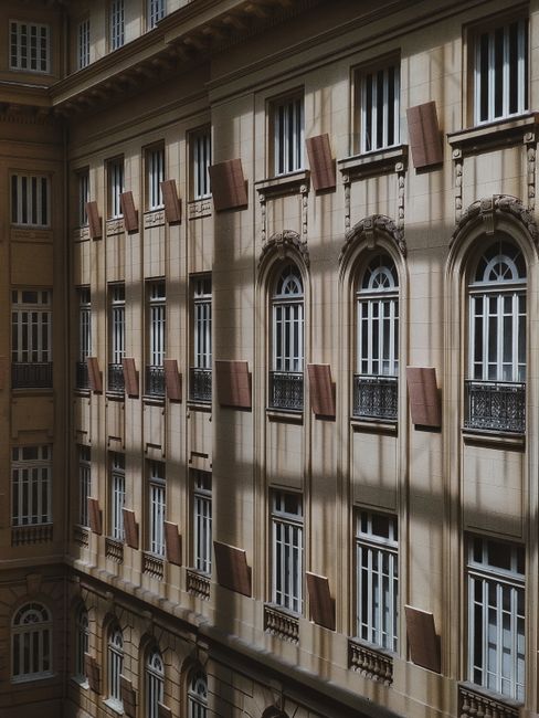 Elegant urban facade showcasing classic arched windows in MG, Brazil, under natural daylight.