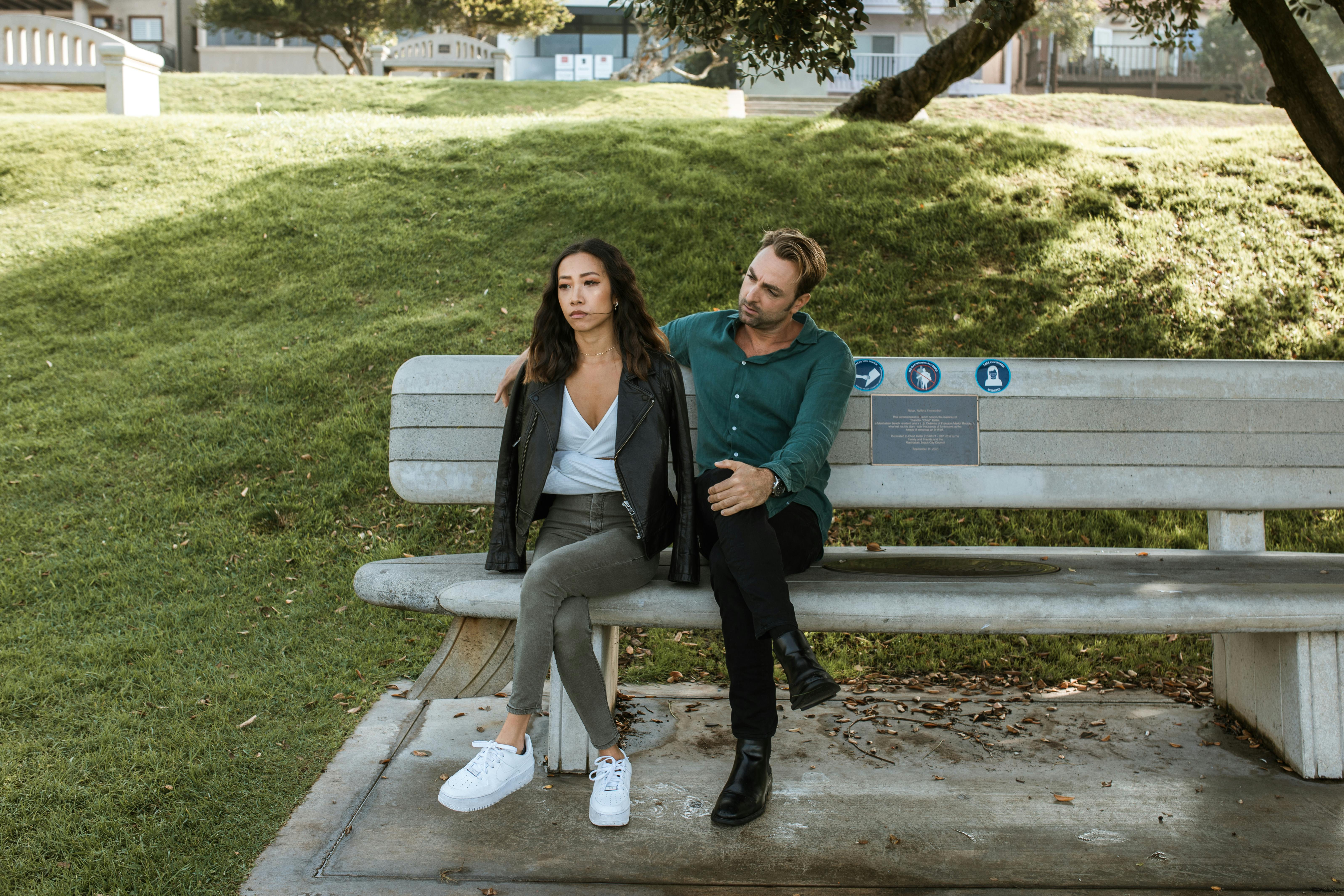 man and woman sitting on a bench having a discussion