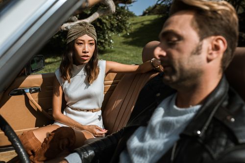 Free A couple having a serious conversation inside a convertible car on a sunny day, reflecting relationship dynamics. Stock Photo