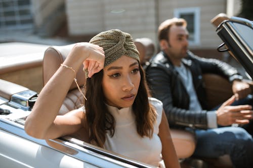 Free Woman in White Tank Top Sitting In A Car Feeling Annoyed Stock Photo