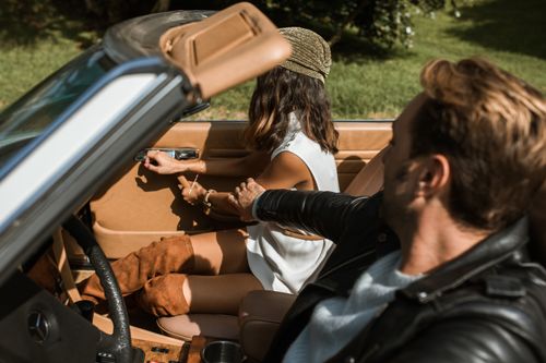 Free A couple having an argument in a convertible car during a summer day outdoors. Stock Photo